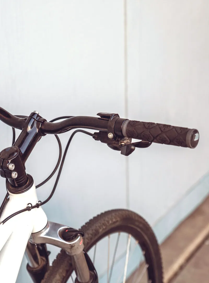 A bicycle in a workshop stand mid-repair